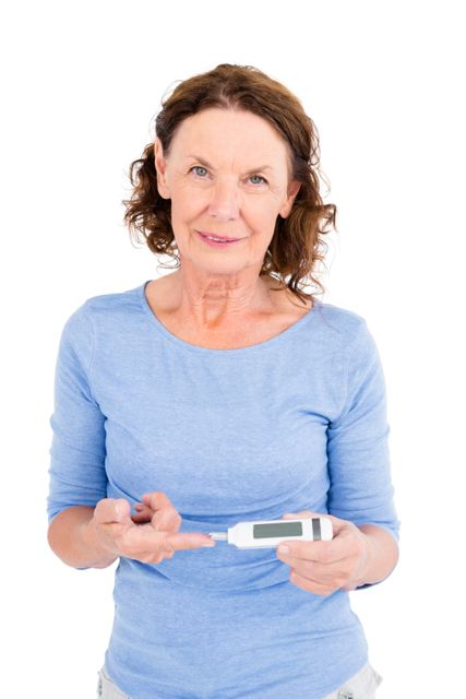 Portrait of smiling mature woman using blood glucose monitor - Download Free Stock Photos Pikwizard.com