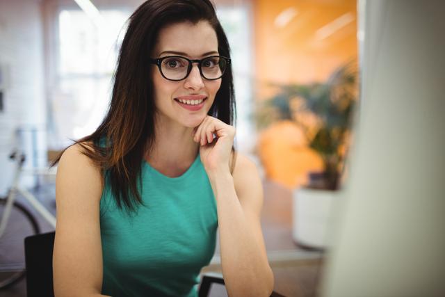 Portrait of beautiful female executive sitting at her desk in office