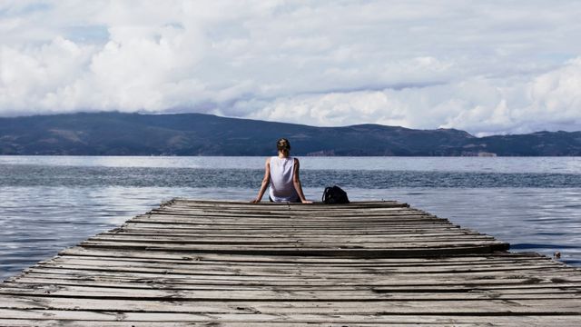 Person Sitting on Brown Wooden Dock Under Cloudy Blue Sky - Download Free Stock Photos Pikwizard.com