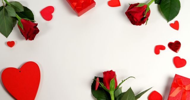 Red roses, gift boxes and heart shape of confetti on white surface in circle formation - Download Free Stock Photos Pikwizard.com