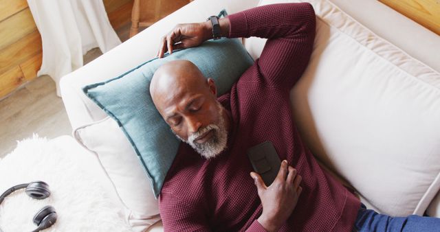 Happy senior african american man spending time in log cabin, sleeping on sofa, slow motion - Download Free Stock Photos Pikwizard.com