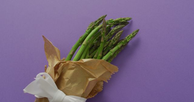 Image of fresh asparagus wrapped with white ribbon and copy space over lilac background - Download Free Stock Photos Pikwizard.com