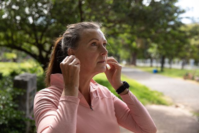 Senior female woman using wireless earphones in the park - Download Free Stock Photos Pikwizard.com