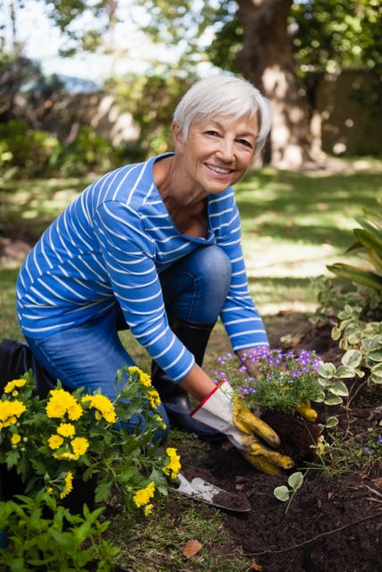 Portrait of smiling senior woman planting flowers - Download Free Stock Photos Pikwizard.com