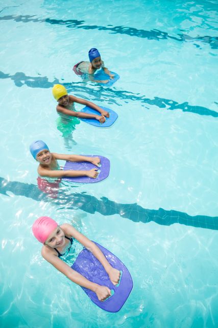 Children using kickboard while swimming in pool - Download Free Stock Photos Pikwizard.com