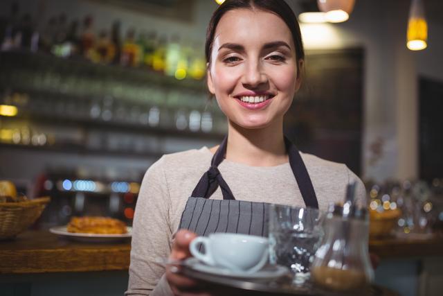 Portrait of waitress holding cup of coffee - Download Free Stock Photos Pikwizard.com