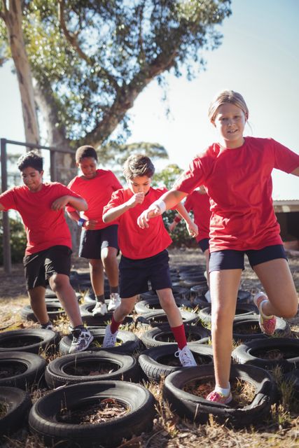 Kids running over tyres during obstacle course training - Download Free Stock Photos Pikwizard.com