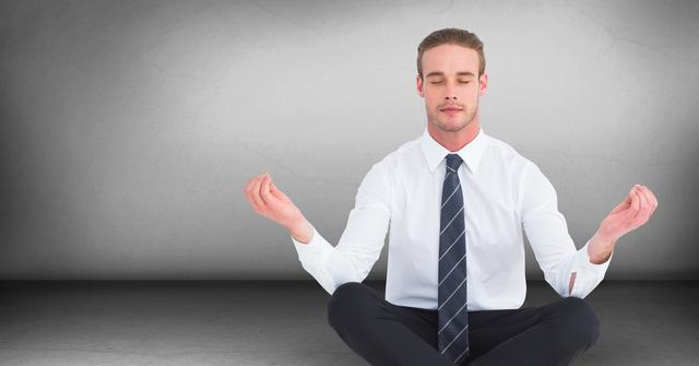 Business man meditating in grey room - Download Free Stock Photos Pikwizard.com