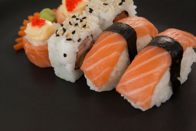 Maki, uramaki and nigiri sushi served in black plate against white background - Download Free Stock Photos Pikwizard.com