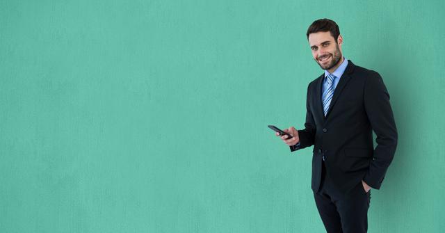 Happy businessman holding smart phone against green background - Download Free Stock Photos Pikwizard.com