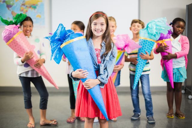 Happy kids holding gifts in classroom - Download Free Stock Photos Pikwizard.com