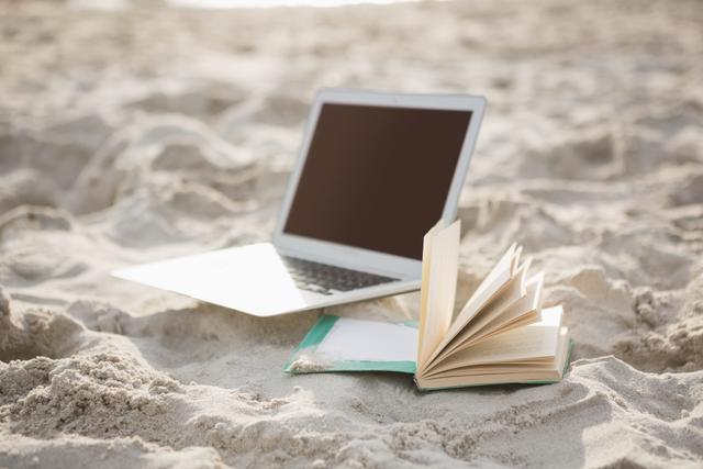 Open book and laptop on sand - Download Free Stock Photos Pikwizard.com