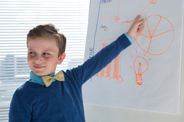 Boy as business executive presenting on white board - Download Free Stock Photos Pikwizard.com