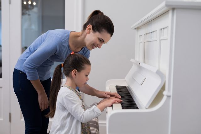 Mother assisting daughter in playing piano - Download Free Stock Photos Pikwizard.com