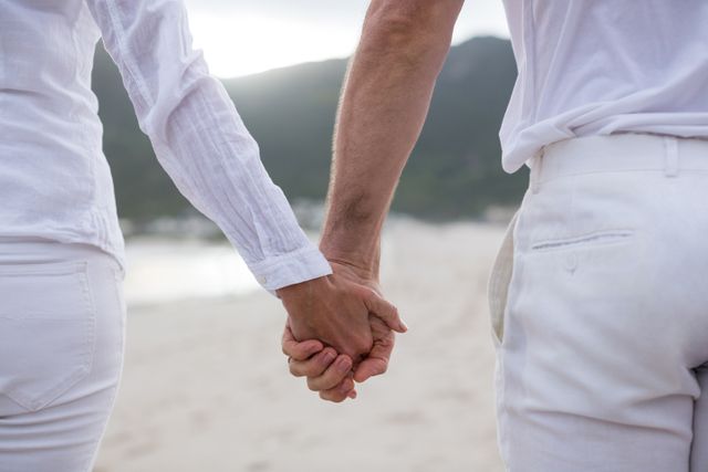 Couple standing with holding hands on the beach - Download Free Stock Photos Pikwizard.com