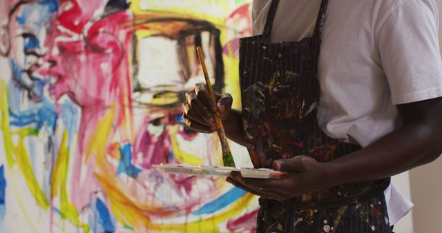 Mid section of african american male artist wearing apron painting on canvas at art studio - Download Free Stock Photos Pikwizard.com