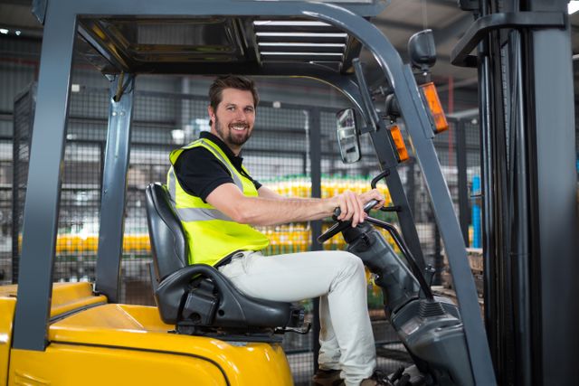 Portrait of smiling factory worker driving forklift - Download Free Stock Photos Pikwizard.com