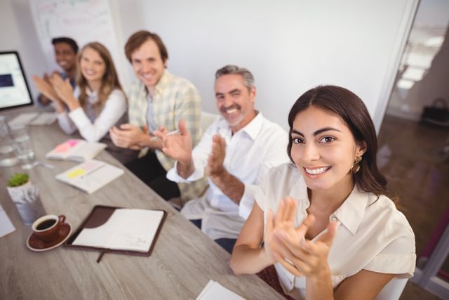 Smiling business people applauding during presentation in office - Download Free Stock Photos Pikwizard.com