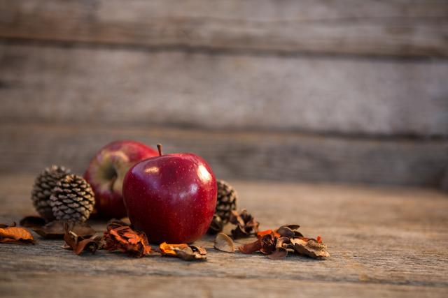 Apple and pine cone on wooden plank - Download Free Stock Photos Pikwizard.com
