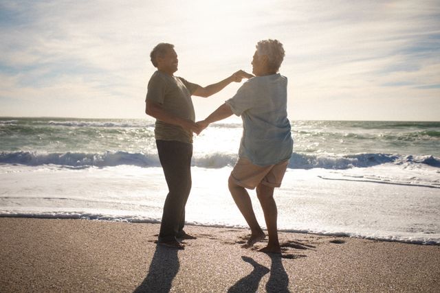 Full length of happy senior couple dancing on shore at beach against sky. lifestyle, love and weekend.