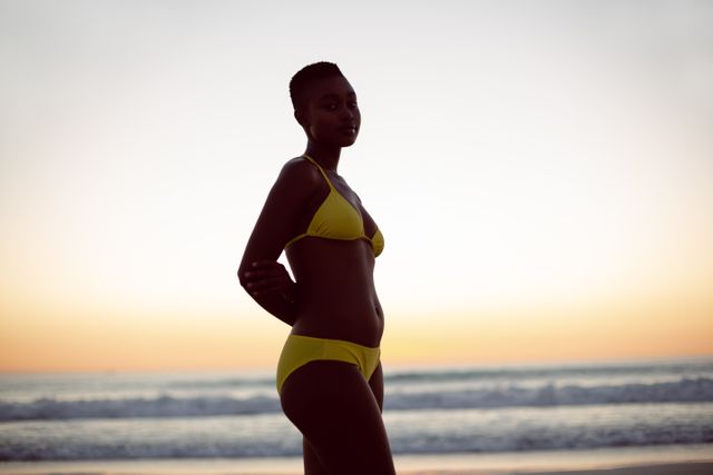 Young woman in bikini standing on the beach - Download Free Stock Photos Pikwizard.com