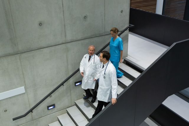 Doctors and surgeons interacting with each other on staircase - Download Free Stock Photos Pikwizard.com