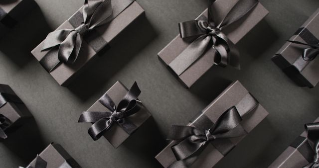 Overhead view of black gift boxes tied with black ribbons on black background - Download Free Stock Photos Pikwizard.com