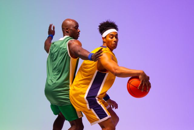 Two african american male basketball players in action, in purple and green  light, copy space from Pikwizard