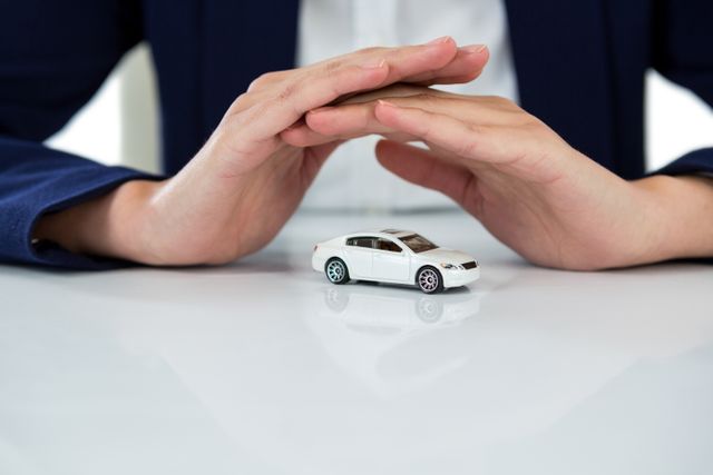 Businesswoman protecting toy car with hands - Download Free Stock Photos Pikwizard.com