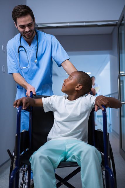 Male nurse interacting with child patient in corridor - Download Free Stock Photos Pikwizard.com