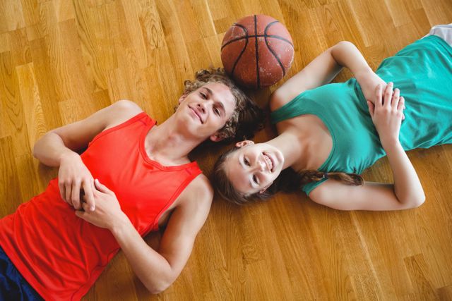 Overhead portrait of friends lying on floor in basketball court