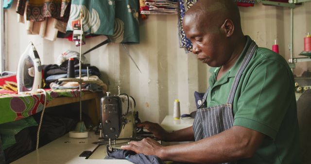 African american male tailor using sewing machine in workshop - Download Free Stock Photos Pikwizard.com