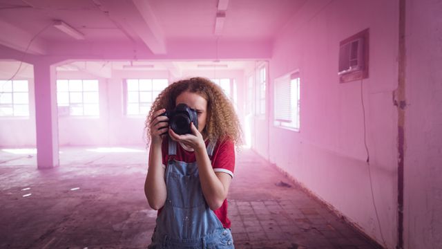 Young woman taking a photo in a warehouse - Download Free Stock Photos Pikwizard.com