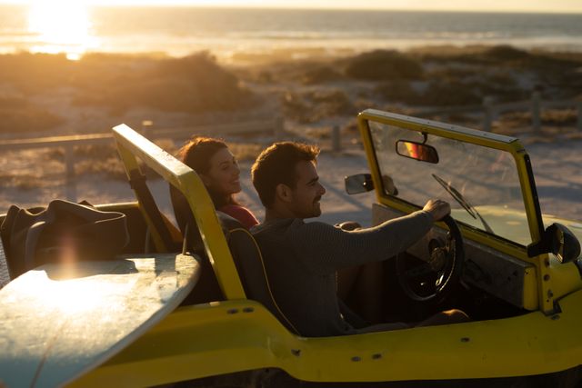 Happy caucasian couple driving beach buggy on beach at sunset, smiling - Download Free Stock Photos Pikwizard.com