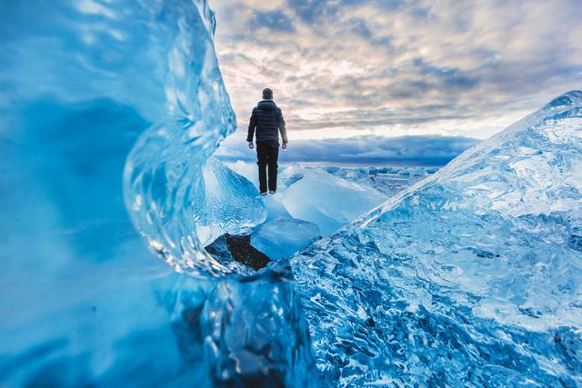a man standing on an ice cliff - Download Free Stock Photos Pikwizard.com