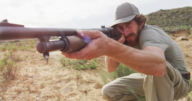 Kneeling caucasian male survivalist taking aim with hunting rifle in wilderness - Download Free Stock Photos Pikwizard.com