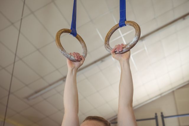 Woman holding gymnastic rings in gym