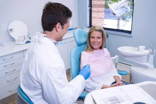 Smiling patient discussing with dentist - Download Free Stock Photos Pikwizard.com