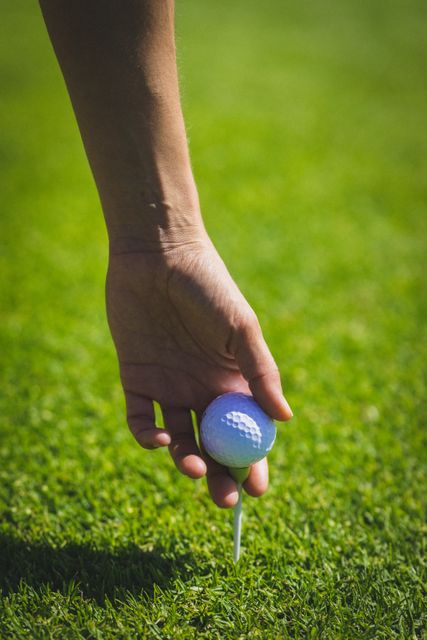 Close up of hand keeping golf ball on tee at golf course - Download Free Stock Photos Pikwizard.com