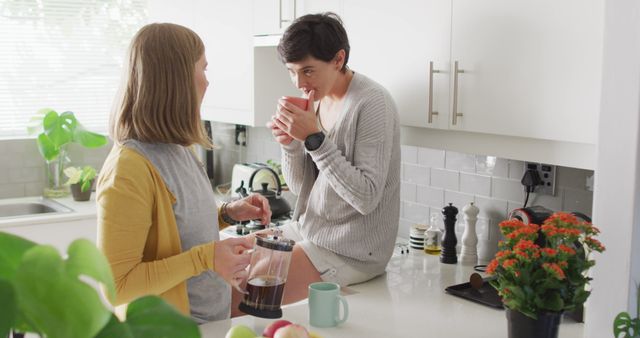 Caucasian lesbian couple having coffee together in the kitchen at home. lgbt relationship and lifestyle concept