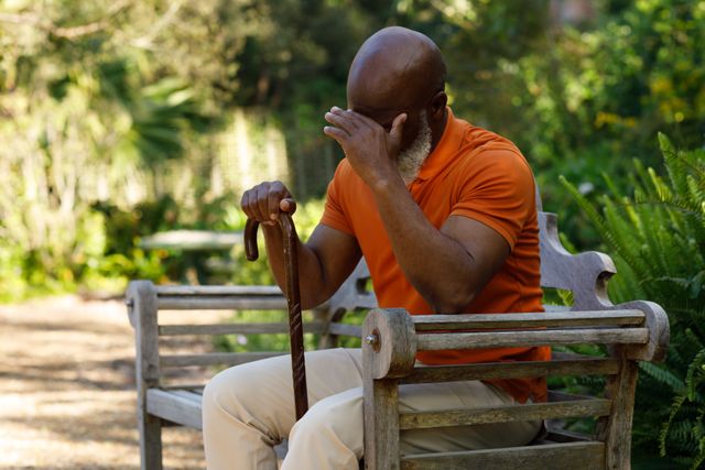 Side view of an old african-american man with a bald head and a white beard sitting on a wooden park - Download Free Stock Photos Pikwizard.com