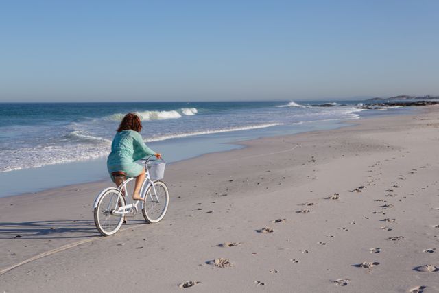Woman riding bicycle on beach in the sunshine - Download Free Stock Photos Pikwizard.com