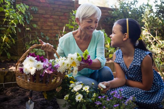 Smiling grandmother with granddaughter holding flower basket - Download Free Stock Photos Pikwizard.com