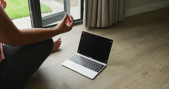Image of plus size african american woman practicing yoga with laptop with copy space. active healthy lifestyle, exercising at home.
