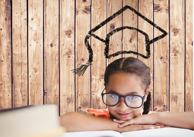 Girl with spectacles resting her head on the book with graduation cap on wooden background - Download Free Stock Photos Pikwizard.com