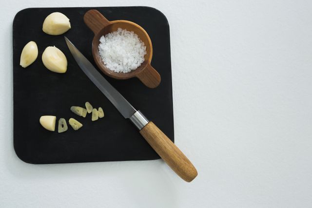 Chopped garlic with bowl of sea salt and knife - Download Free Stock Photos Pikwizard.com