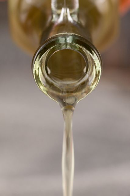 Close up of bottle pouring olive oil - Download Free Stock Photos Pikwizard.com