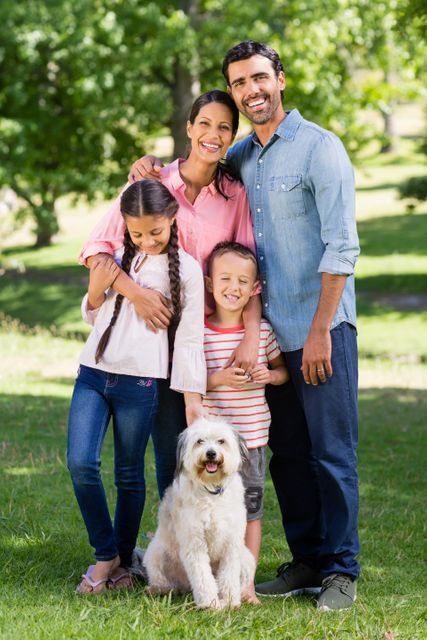 Portrait of happy family with their pet dog standing in park - Download Free Stock Photos Pikwizard.com