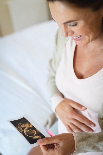 Close-up of smiling caucasian mid adult pregnant woman holding ultrasound scan report - Download Free Stock Photos Pikwizard.com