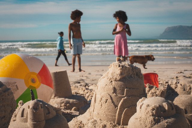 African american children relaxing on beach making sand castle - Download Free Stock Photos Pikwizard.com